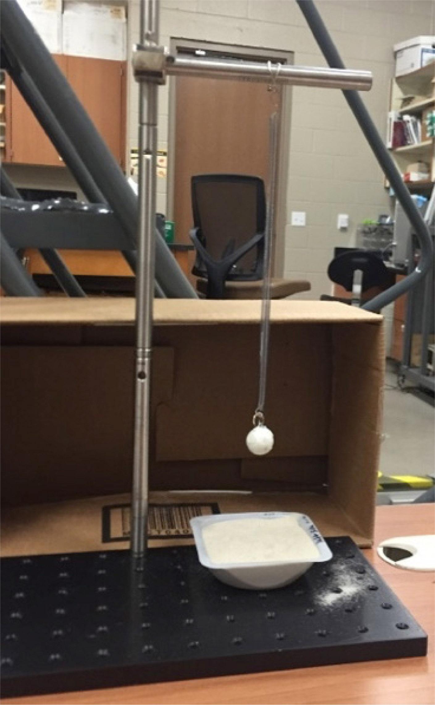 1-g granular impact experiment spring pendulum apparatus.