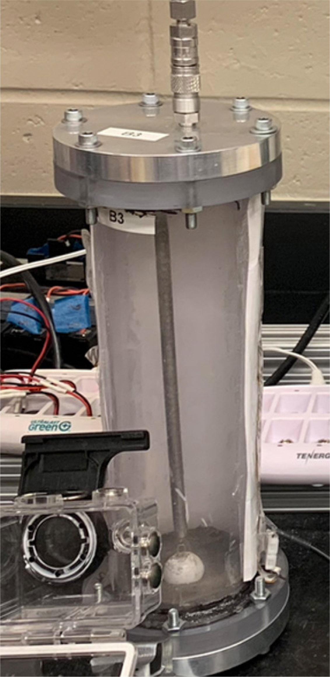 Vacuum drop tower apparatus. The chamber is detached from a vacuum pump shortly before an experiment is performed, and a Swagelok quick-disconnect fitting maintains the vacuum inside the tube for the duration of the experiment.