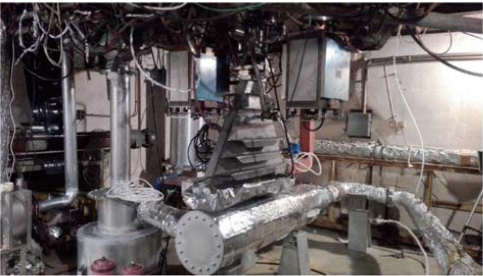 Photo of EBFGT pilot laboratory flow system. Wet scrubber (left) and process vessel (right) under ILU 6 electron accelerator scanning horn.