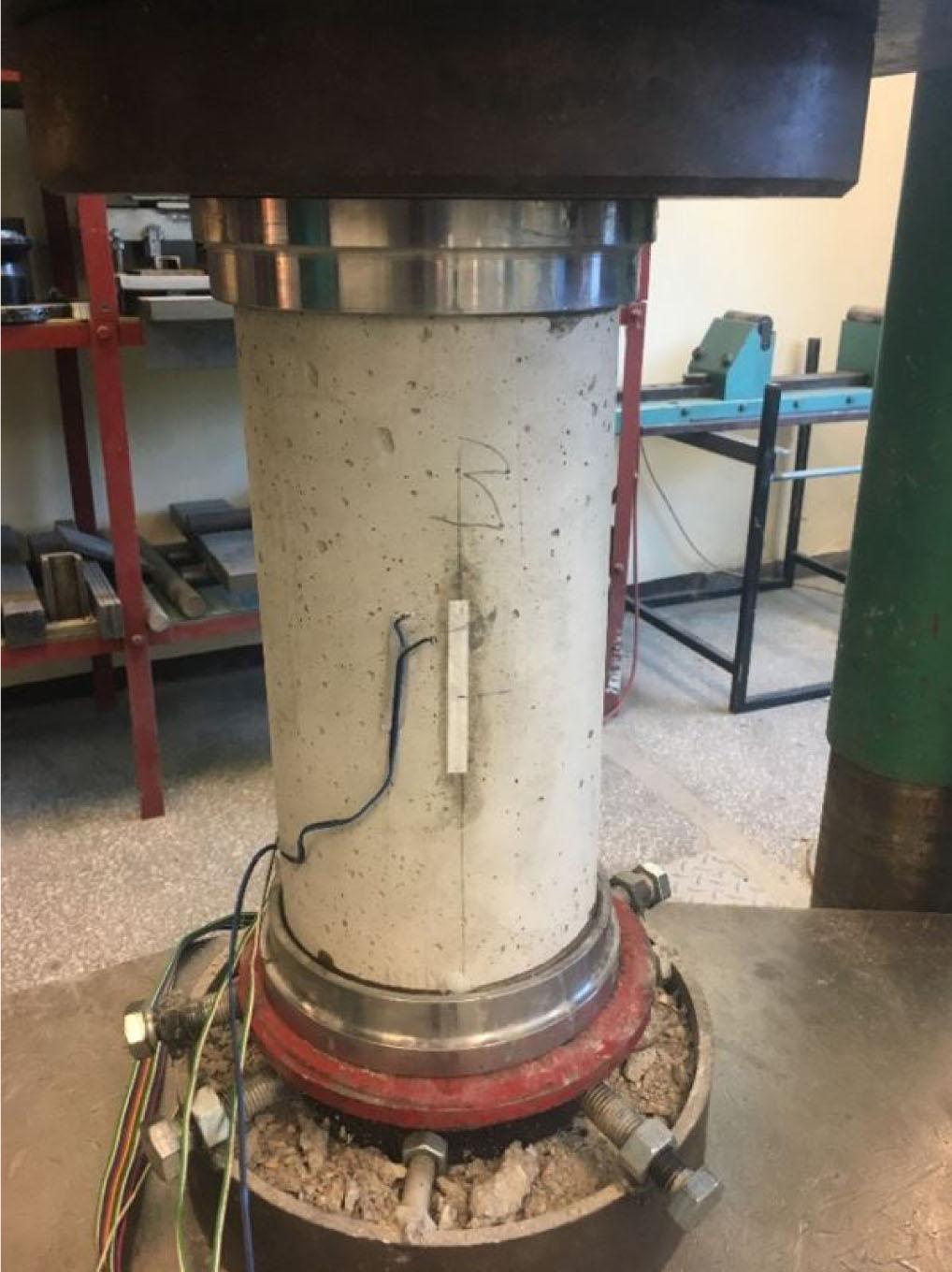 Concrete specimen placed in strength-testing machine.