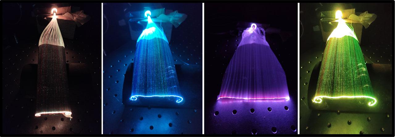 Light emission views of POFs on fabric with different coloured light sources (the light source colors are left to right: white, blue, purple, yellow)