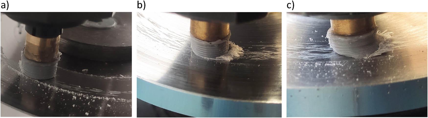 PLA specimen after interaction with a steel disc at parameters: (a) v = 1 m/s and p = 0.05 MPa, visible scattered loose wear products; (b) v = 1 m/s and p = 0.1 MPa, visible “braid, plume” behind the specimen, and “shreds” of plastic on the disc; and (c) v = 1 m/s and p = 0.4 MPa, specimen deformed from temperature.